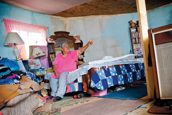 Ruby Kinsel points to the places where the roof leaks in her hogan in Coyote Canyon Wednesday. The chapter has built a new home for Kinsel and her husband but they can't move in because the building has no running water yet.  © 2011 Gallup Independent / Cable Hoover 